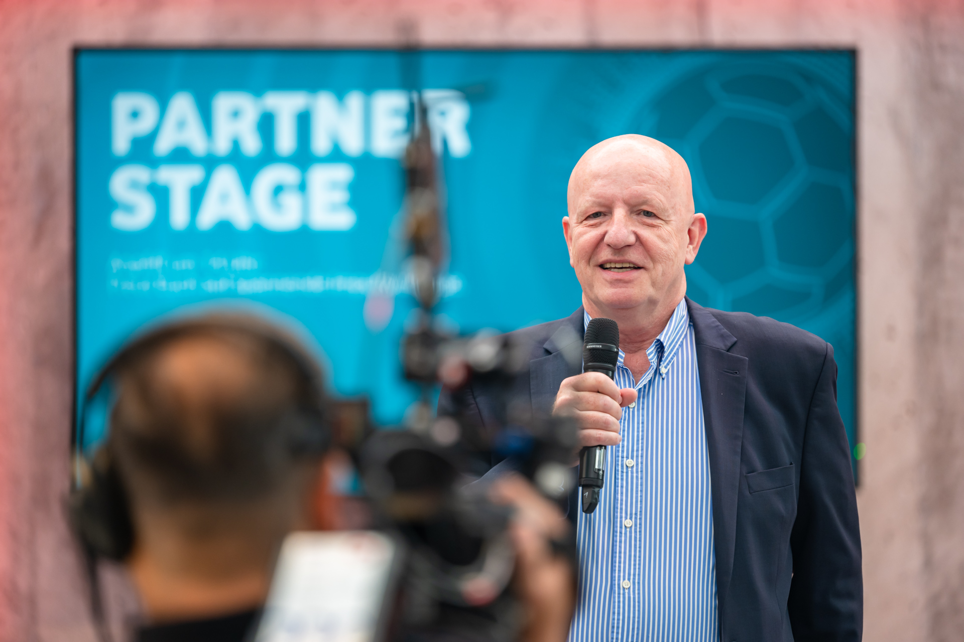 Georg Oecking spricht mit einem Mikrofon auf einer Bühne