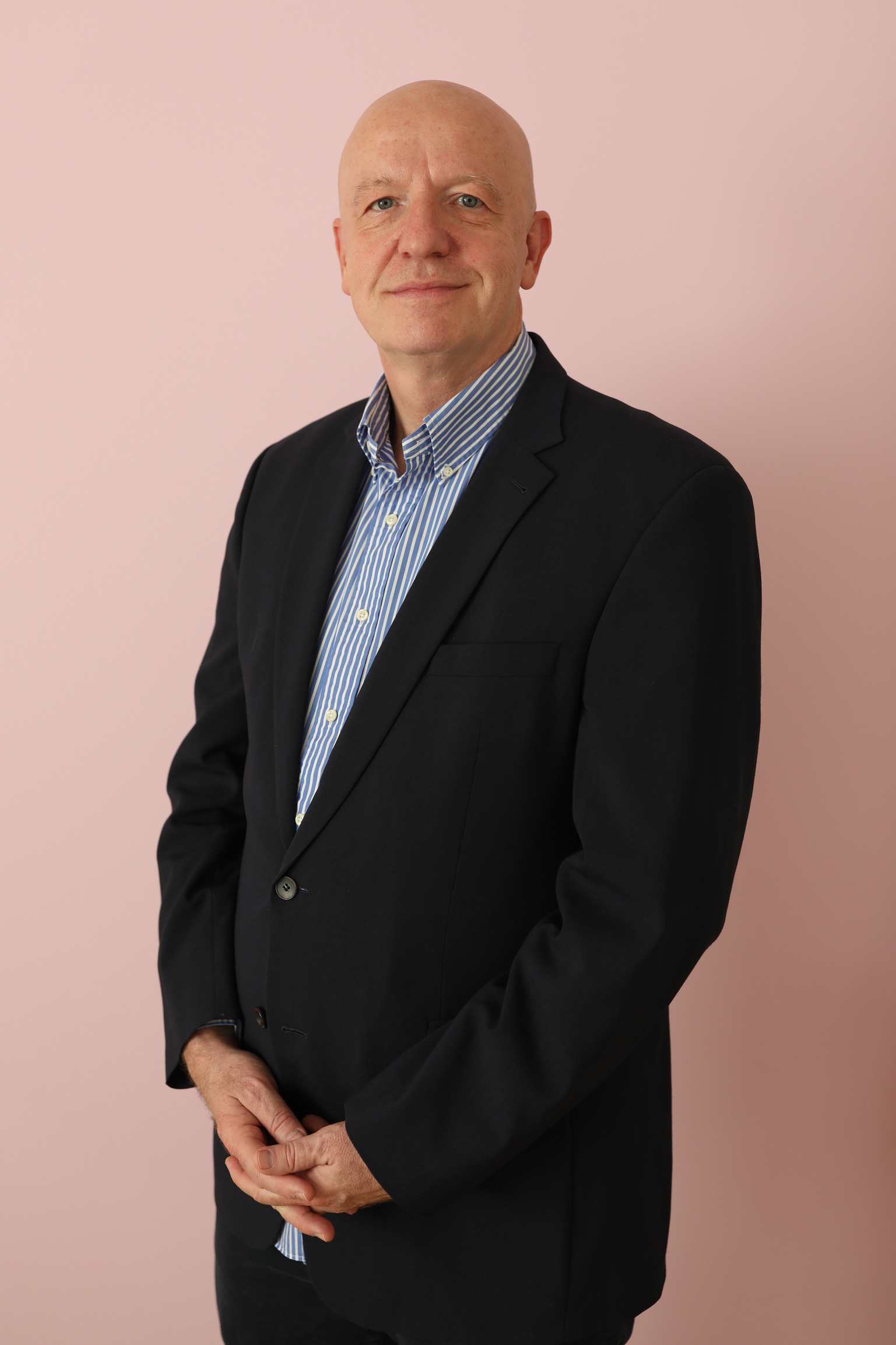 Georg Oecking im dunklen Sakko und gestreiften Hemd